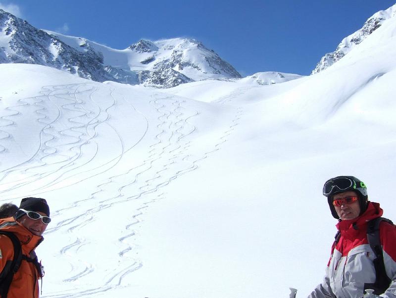 Deux skieurs dévalent une pente recouverte de neige.