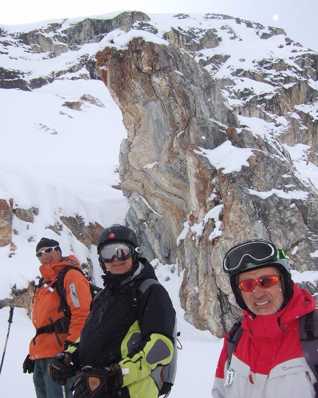 homme en veste rouge et pantalon bleu assis sur une montagne enneigée en plein jour